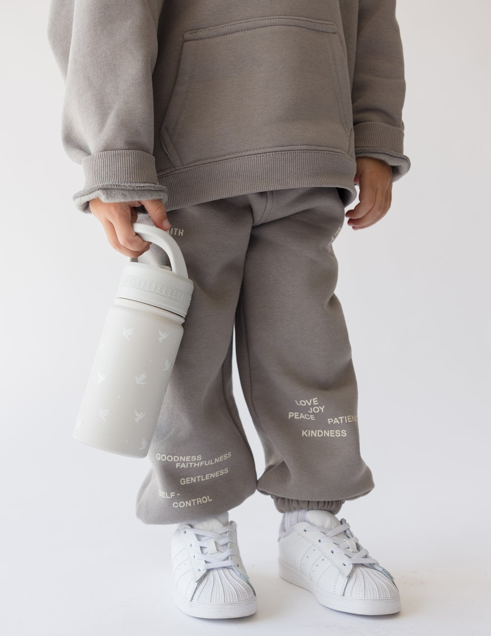Kids water bottle in pale gray, child holding with sweatshirt pocket