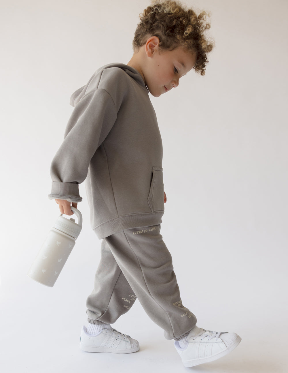 Kids water bottle, pale gray with bird print, carried by child