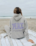 Light gray unisex hoodie with purple "PEACE" graphic on back, hood, and pouch pocket.