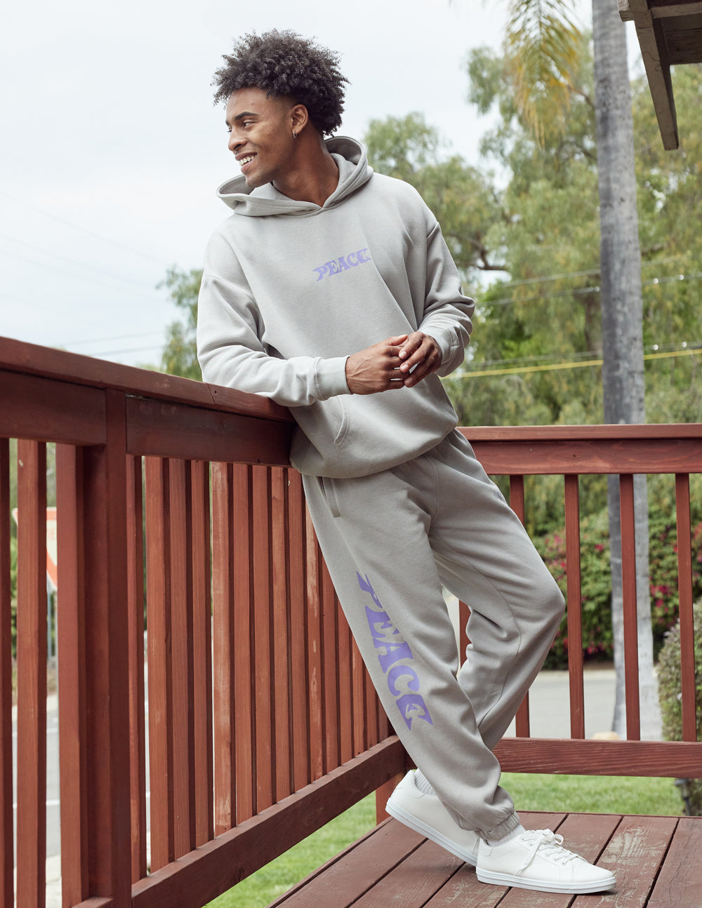 Light gray unisex hoodie with purple "PEACE" logo, hood, and front pouch pocket.