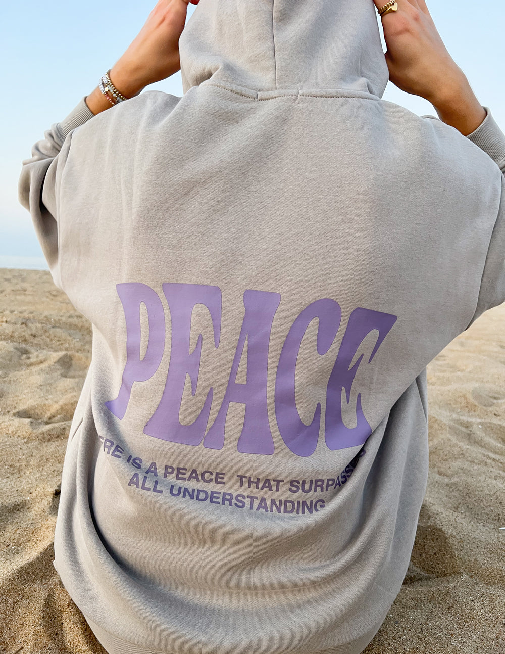 Light gray unisex hoodie, close back view, with large purple "PEACE" graphic and hood.