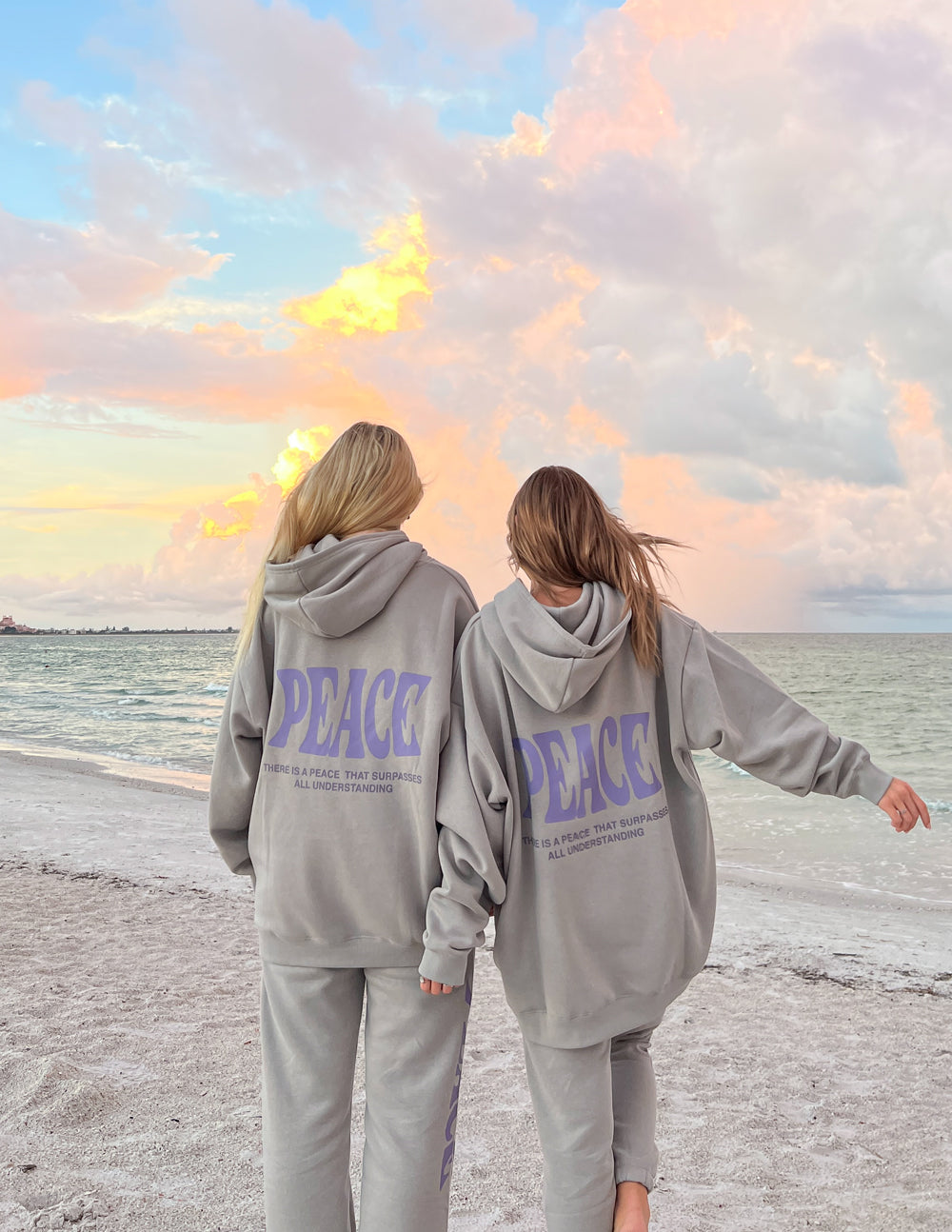Light gray unisex hoodies worn by two people, back logos in purple "PEACE" text.