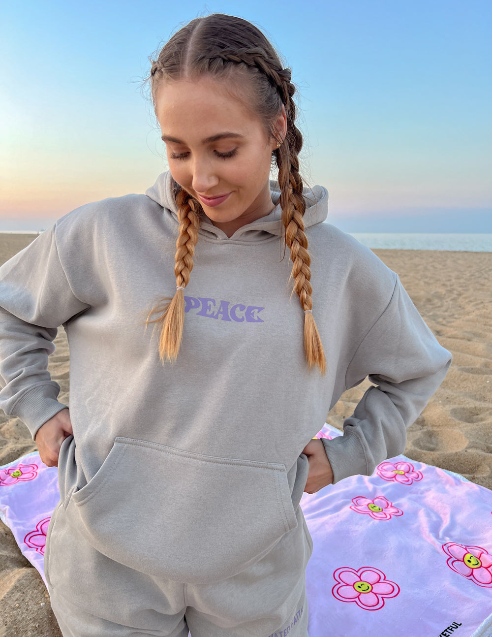 Light gray unisex hoodie with purple "PEACE" chest logo, hood, and front pocket.