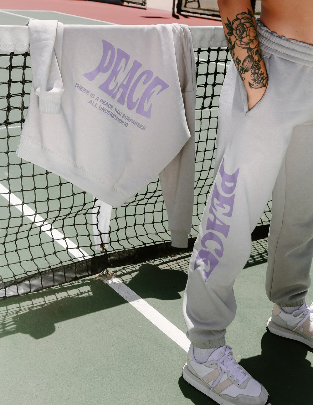 Unisex sweatpants, light gray with purple Peace logo print, close-up
