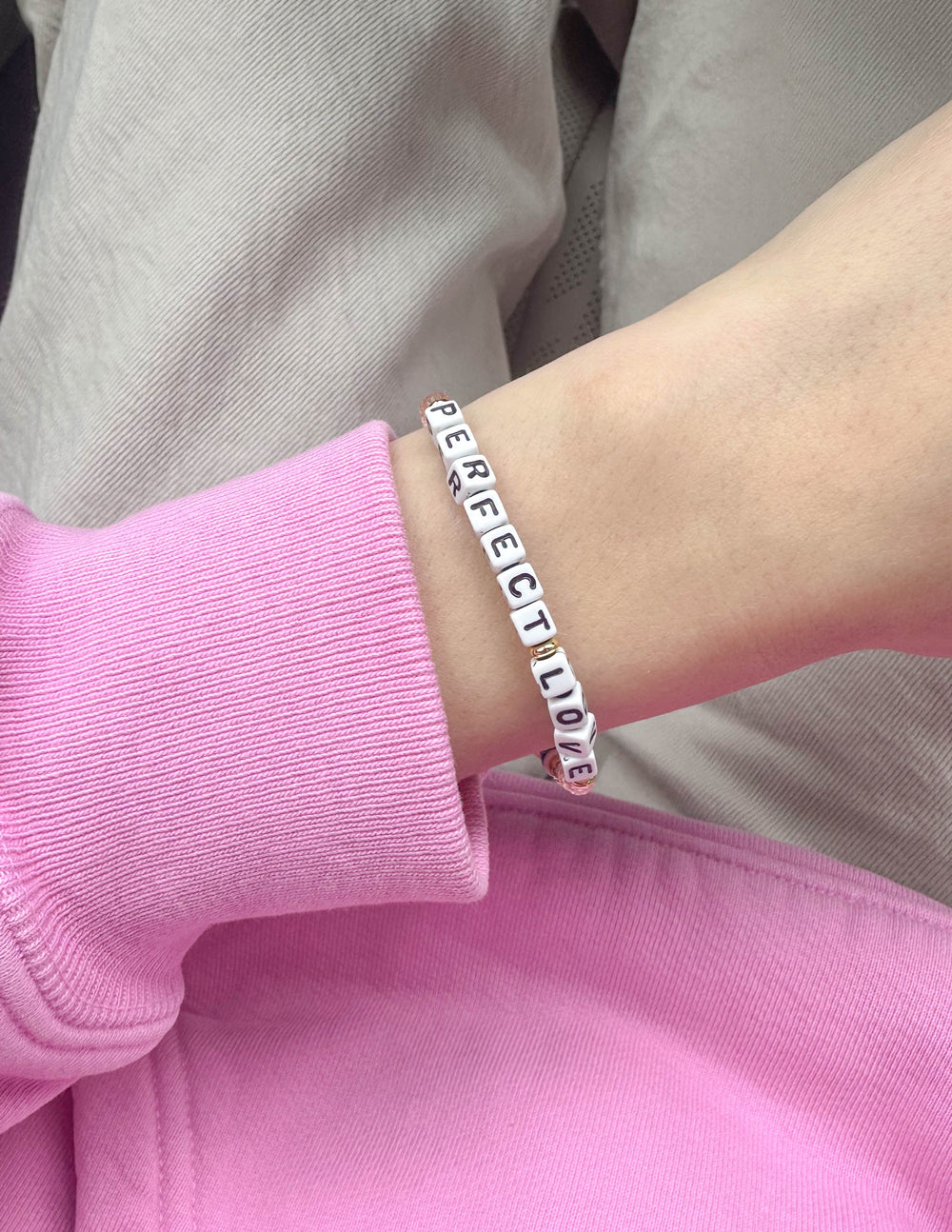 Beaded bracelet on wrist with PerfectLove letter beads in blue and pink