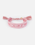 Pink woven bracelet with embroidered pattern and tassels