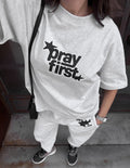 Heather gray heavyweight crewneck T-shirt with black star “pray first” graphic on chest
