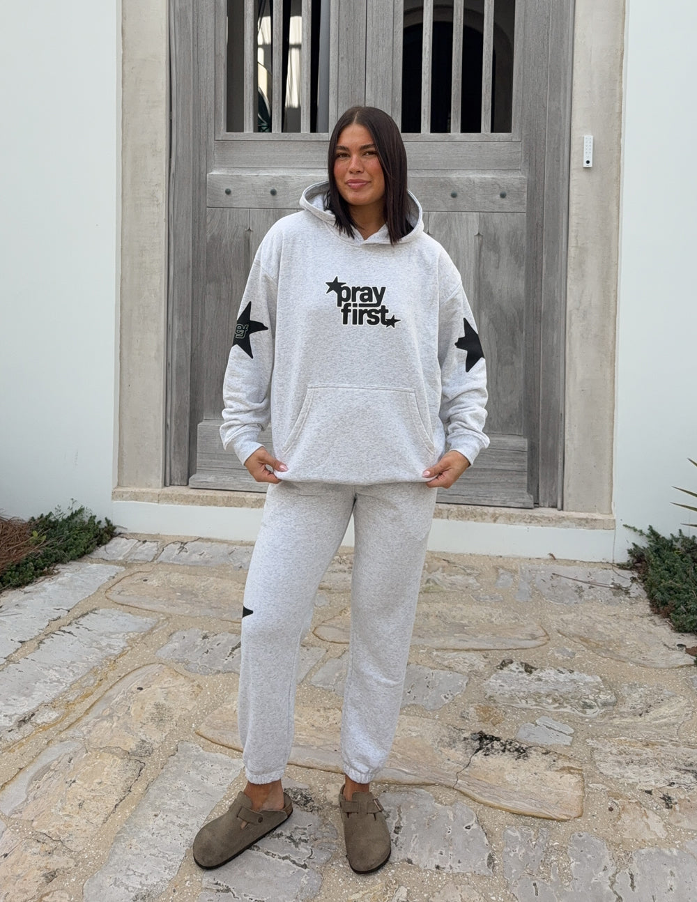 Light gray unisex hoodie, front view with hood and "pray first" logo