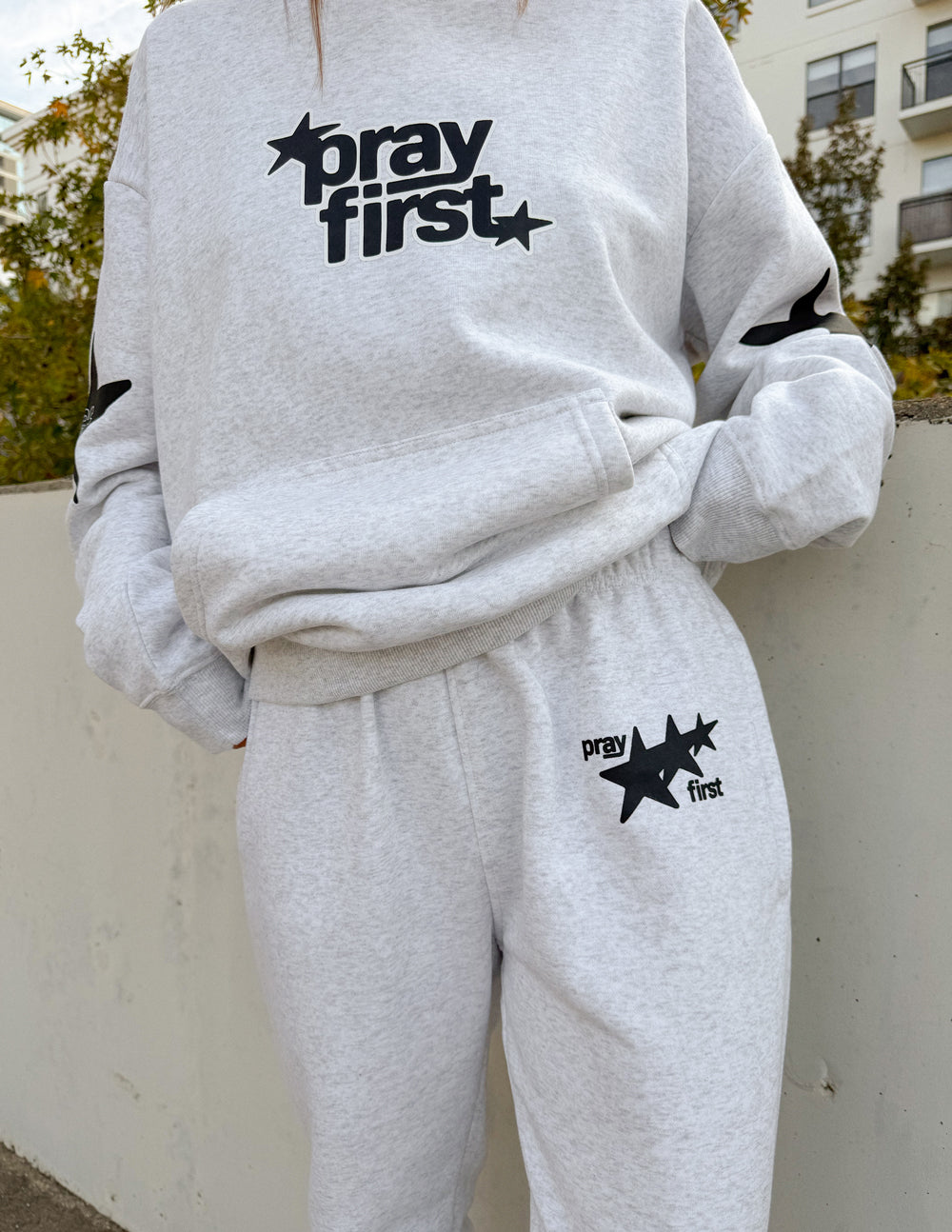 Unisex light gray sweatpants with star 'pray first' logo on thigh