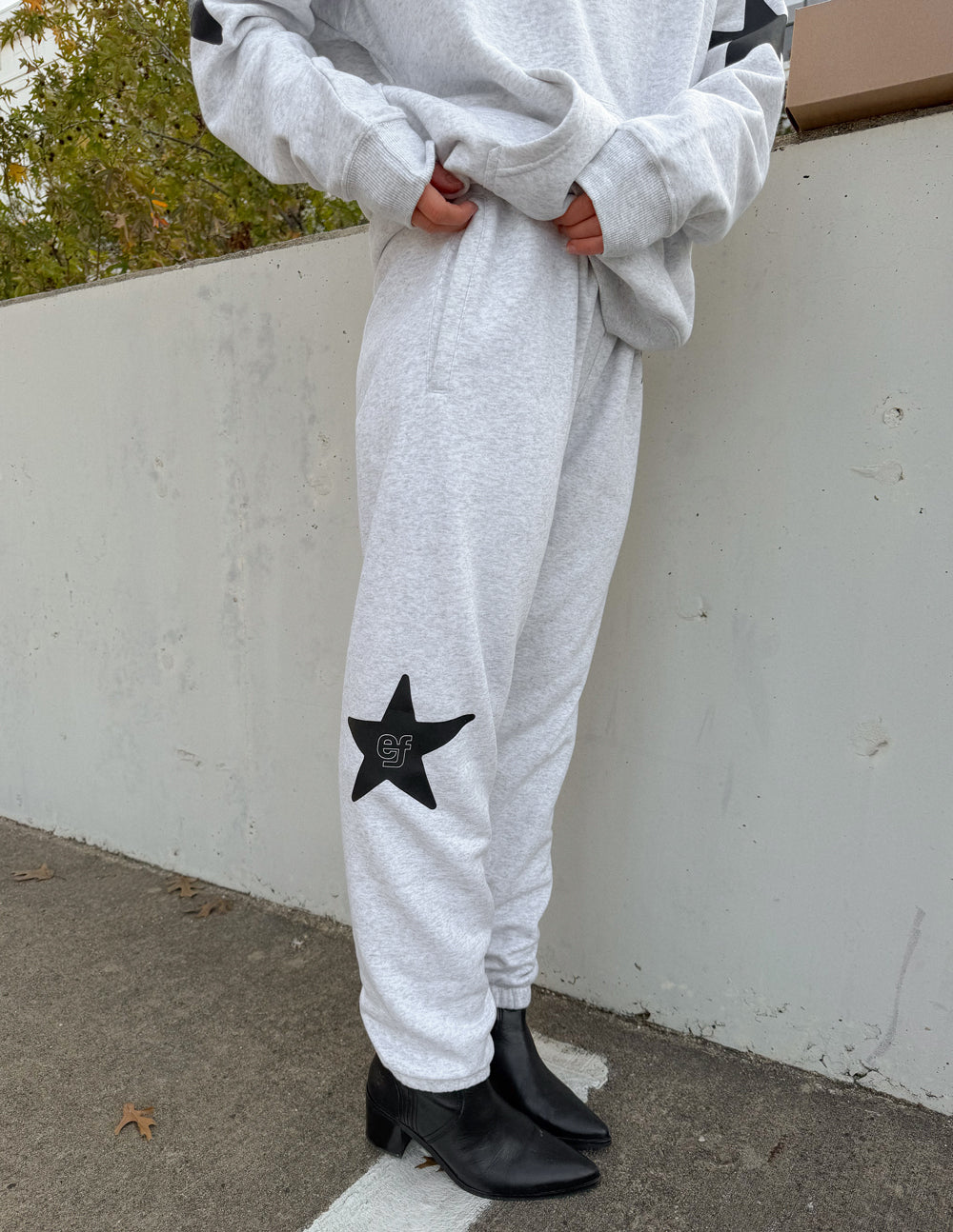 Unisex light gray sweatpants with star logo on lower leg, elastic cuffs