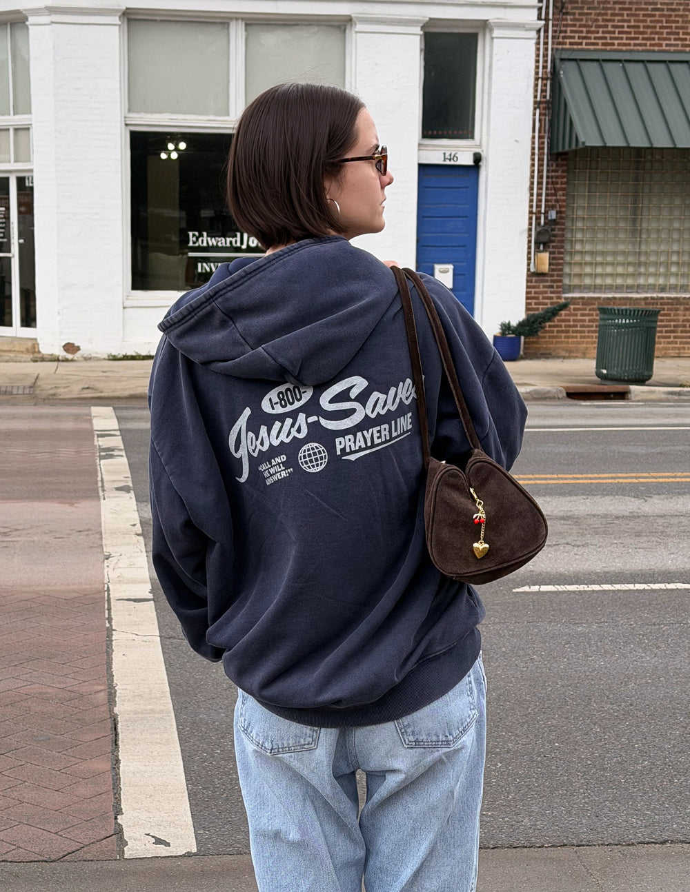 Dark navy unisex hoodie worn from back, hood and “Jesus Saves Prayer Line” print