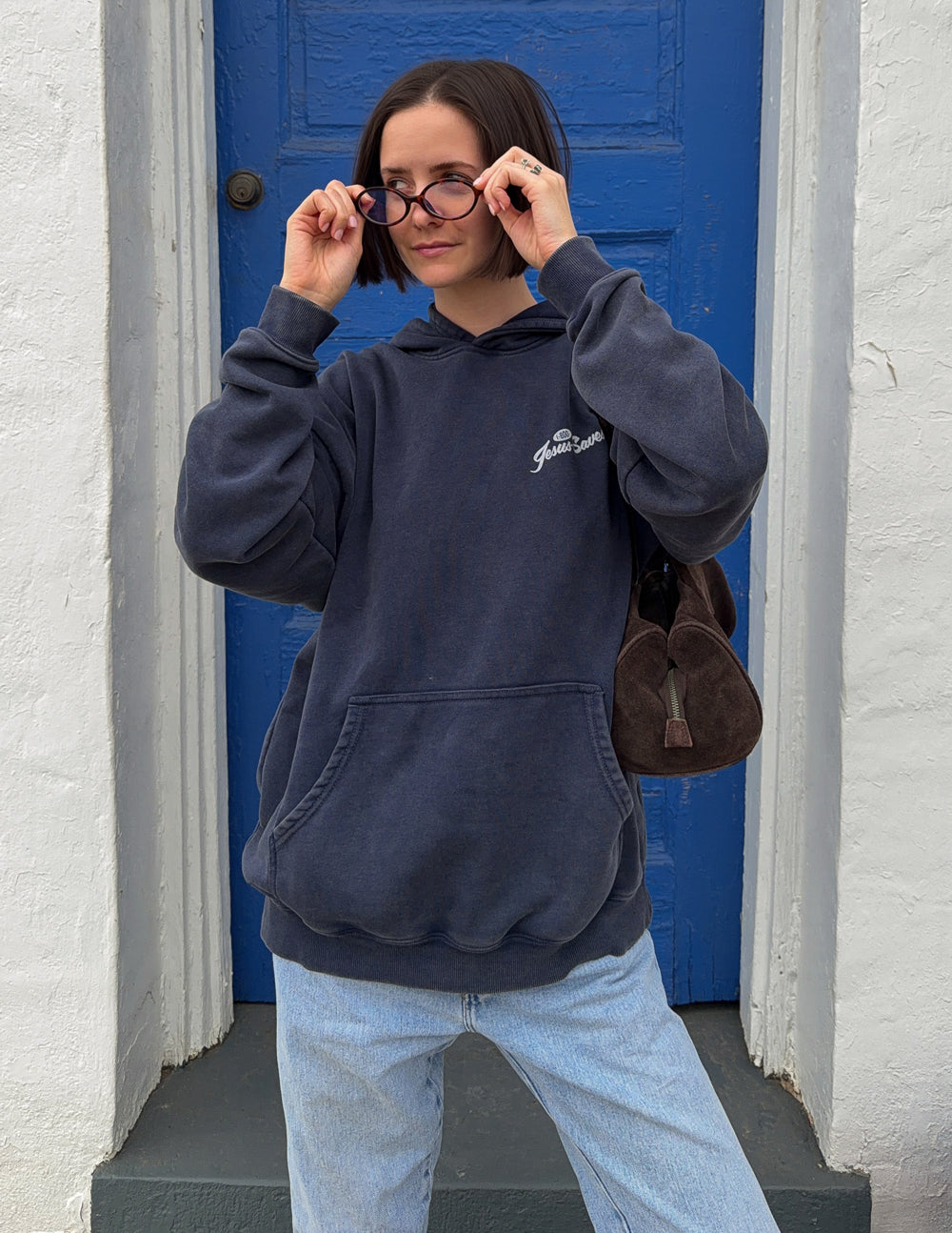 Dark navy unisex hoodie with hood, kangaroo pocket, and small chest “Jesus Saves” logo