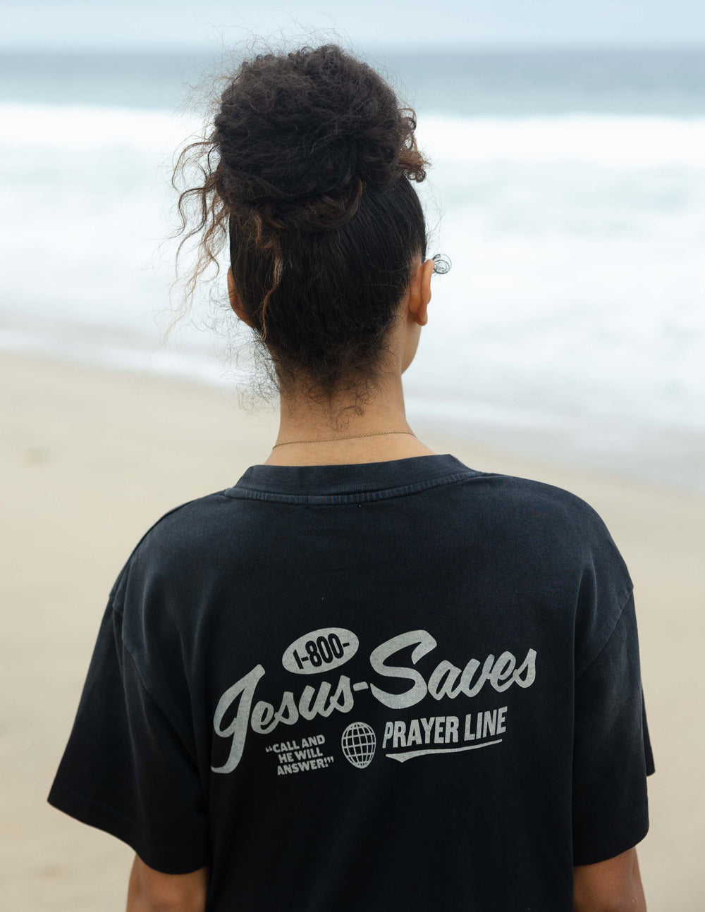 Black unisex T-shirt back view with 'Jesus Saves' and globe icon