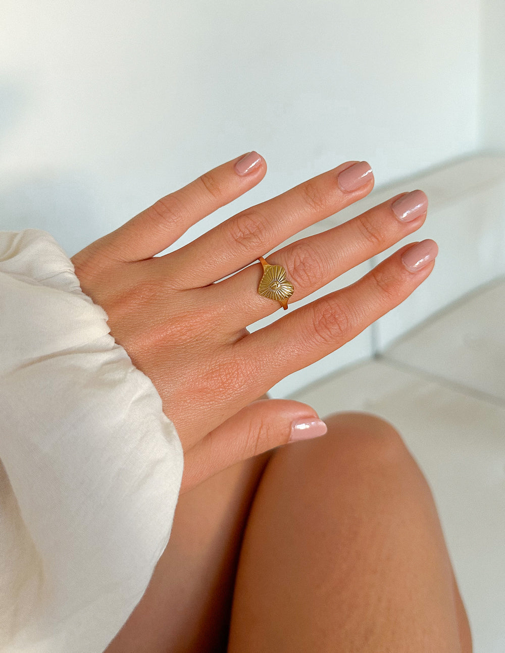 Gold heart-shaped signet ring with cross in center and sunburst rays