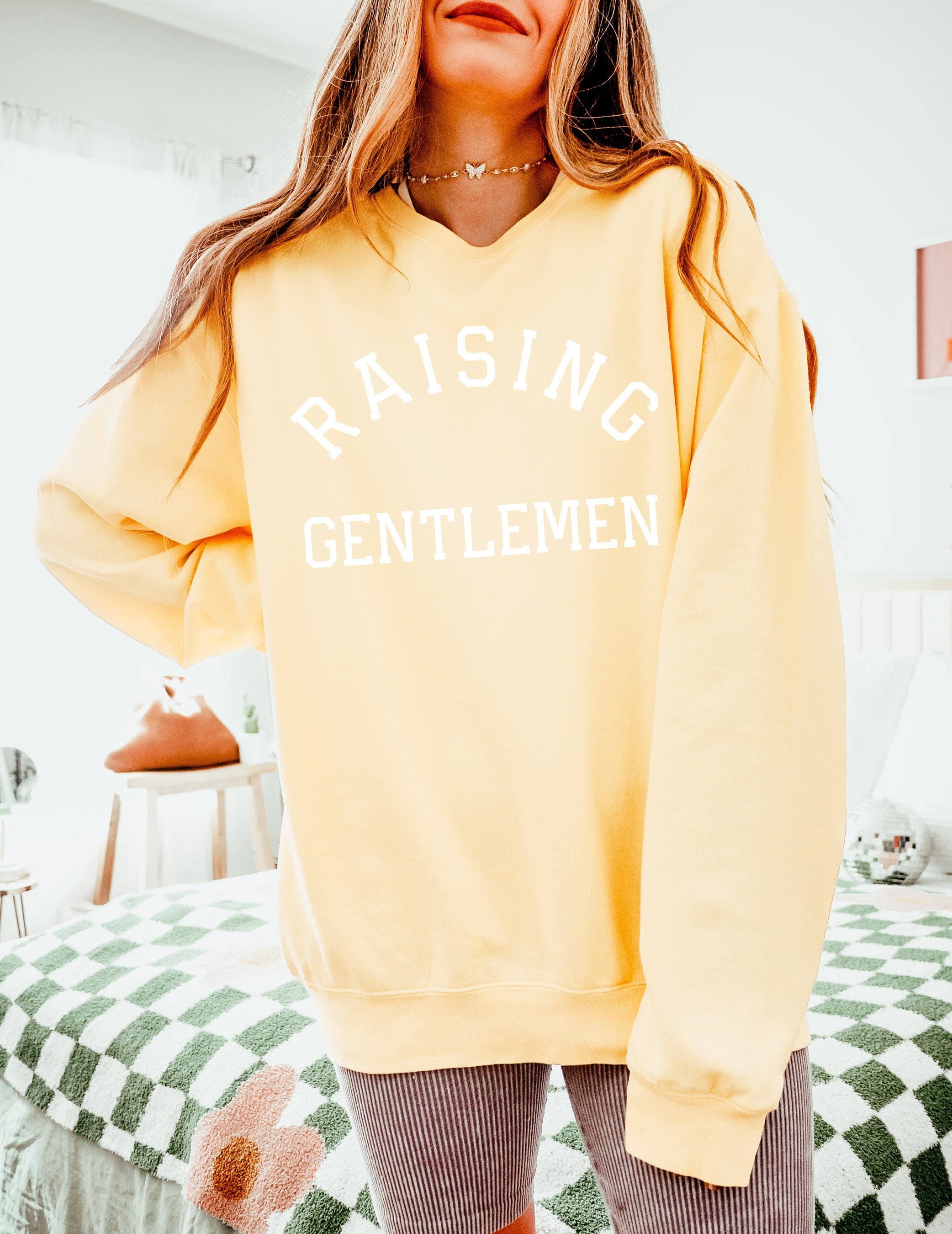 Light cream crewneck sweatshirt with "RAISING GENTLEMEN" text print