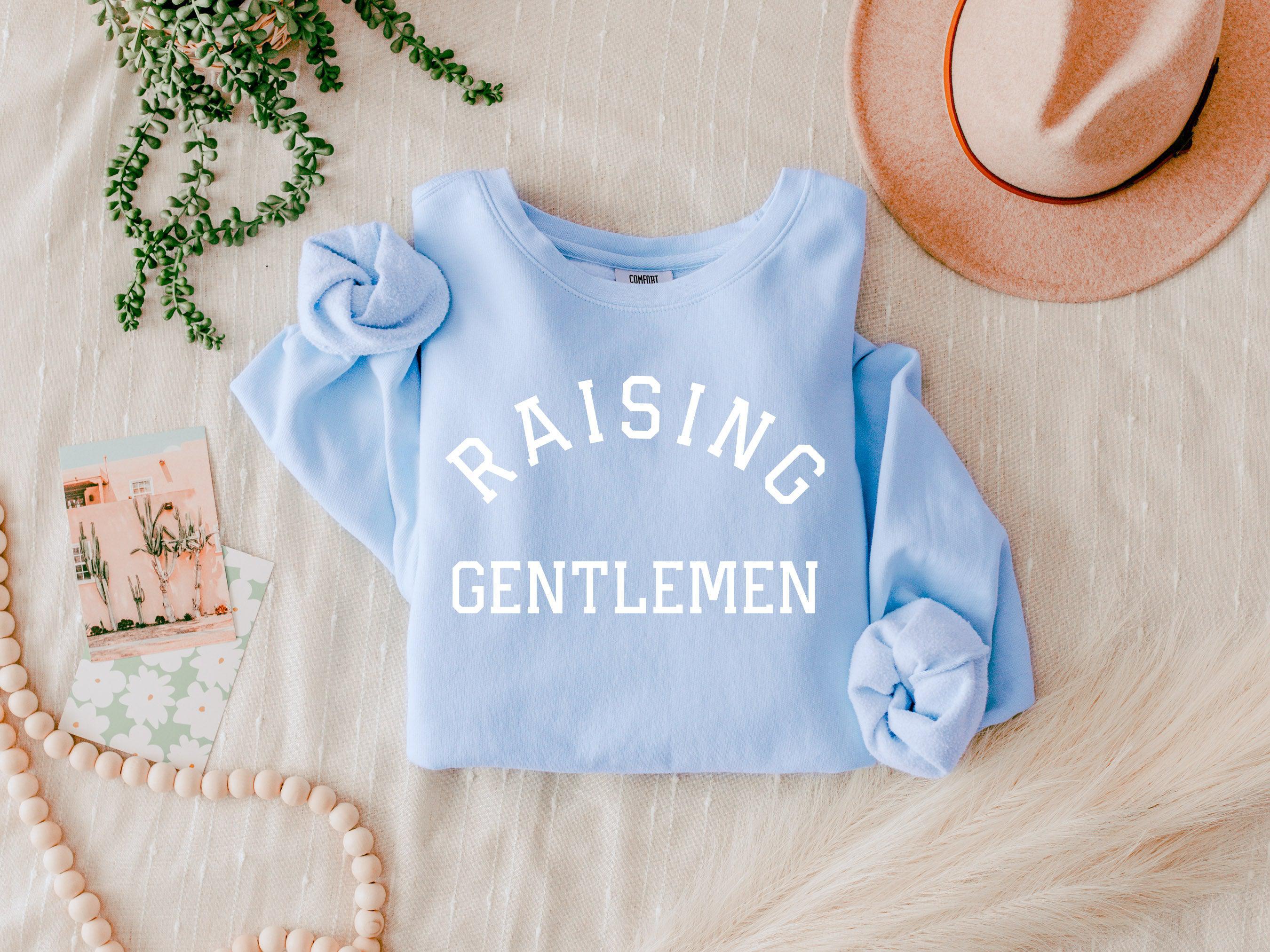 Powder blue crewneck sweatshirt with 'RAISING GENTLEMEN' print, long sleeves
