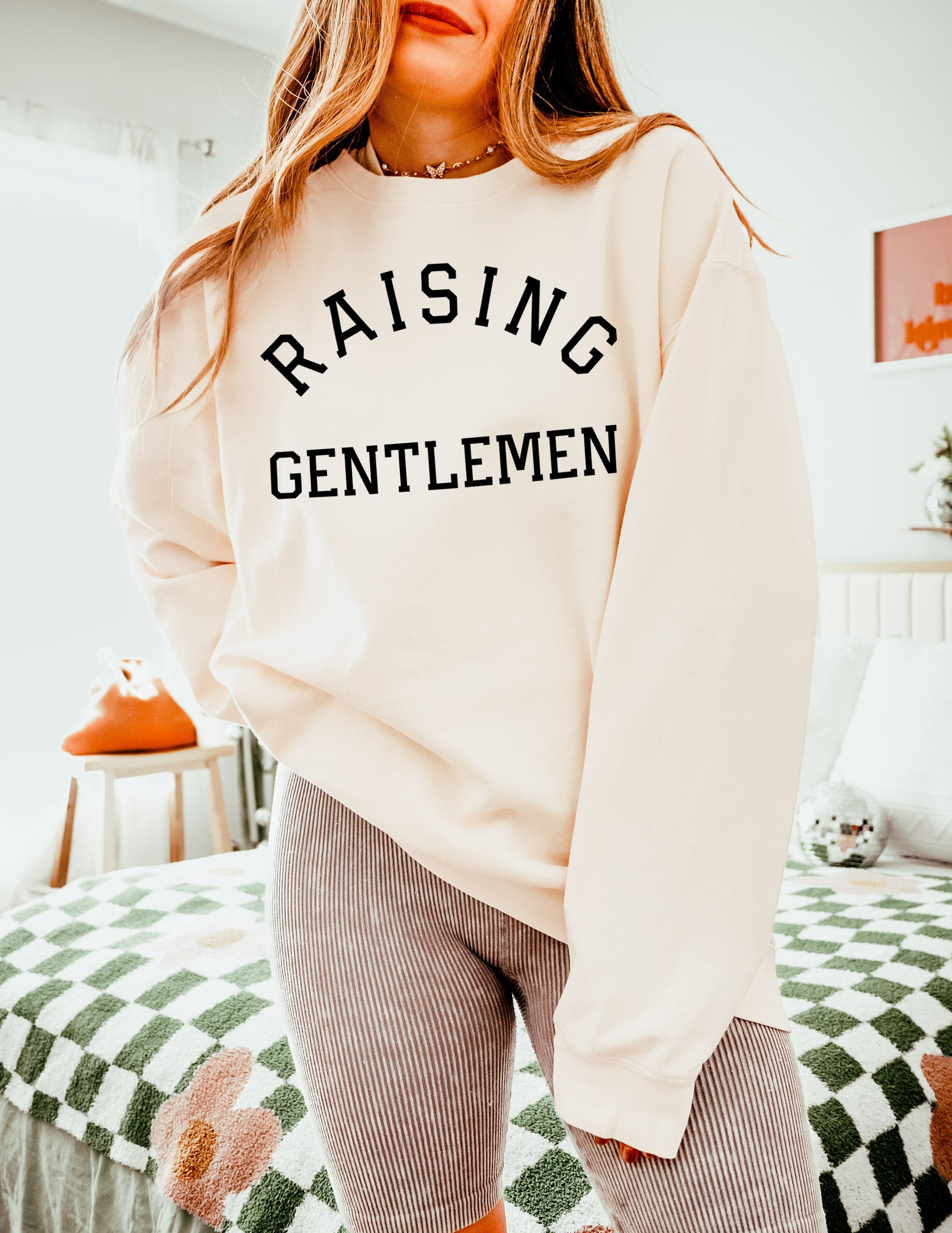 Off-white crewneck sweatshirt with "RAISING GENTLEMEN" text print