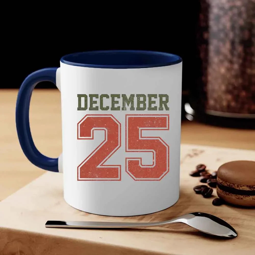 White coffee mug with blue handle and rim, 'DECEMBER 25' graphic.