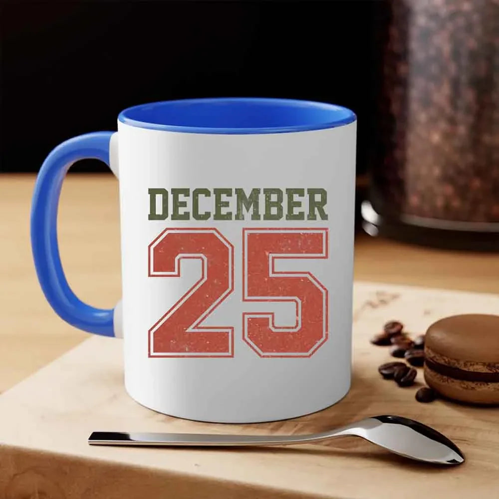 White coffee mug with blue handle and rim, 'DECEMBER 25' print.