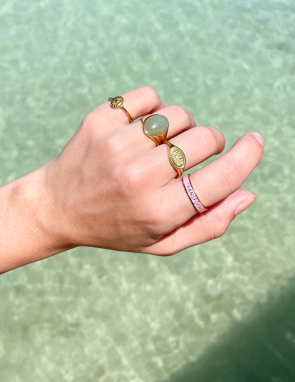Gold-tone sunburst ring on hand, raised round center with radiating ridges