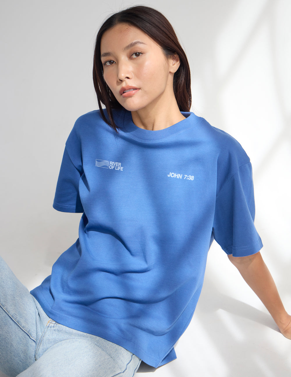 Blue crew-neck graphic T-shirt with small chest logos, John 7:38 on front