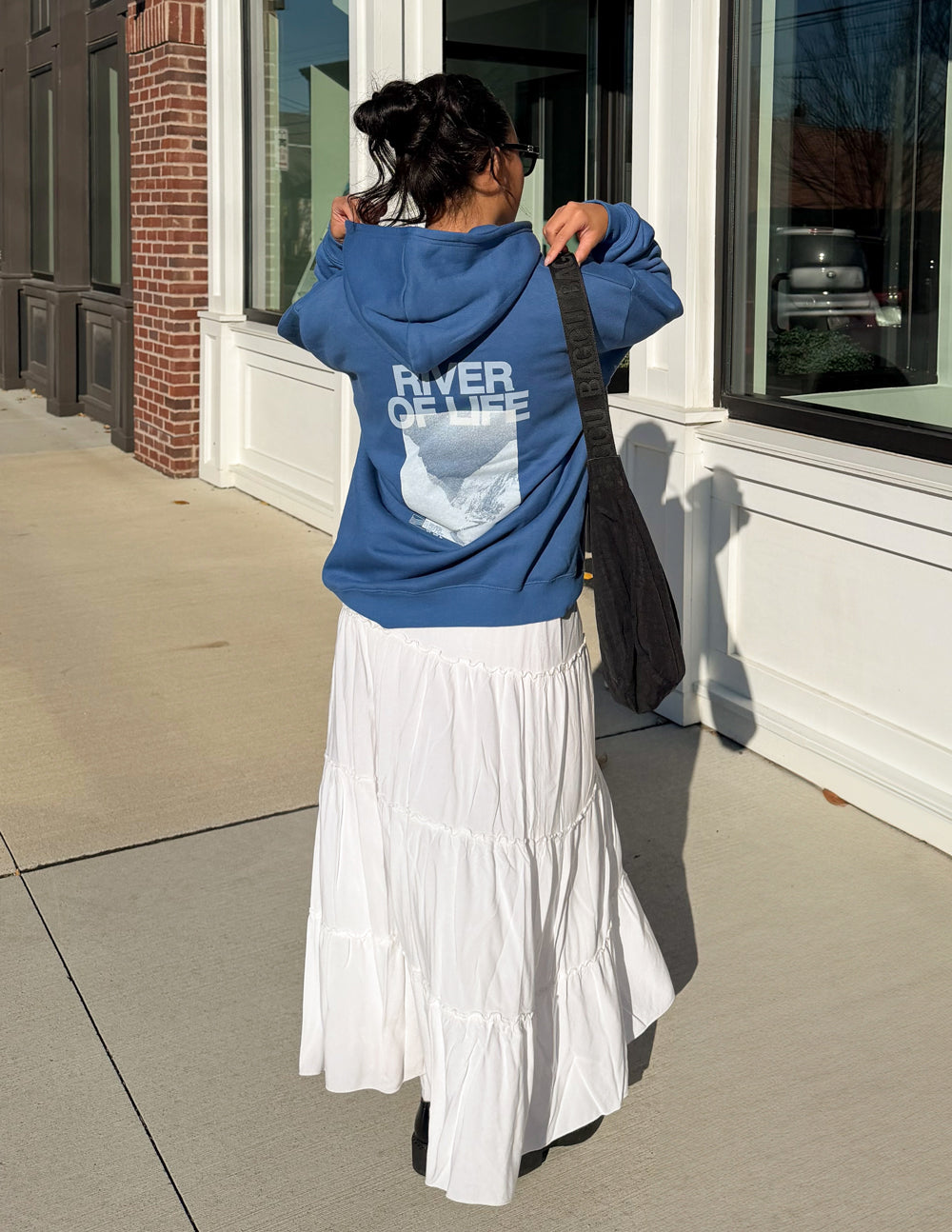 Blue hoodie back view with large “RIVER OF LIFE” print, hood and pocket.