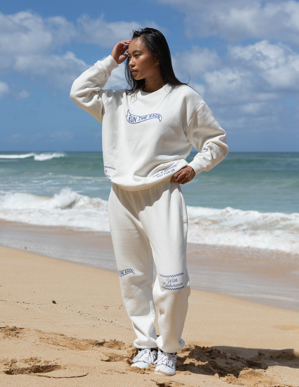 White unisex sweatpants with blue logo marks on chest, thigh, and cuffs
