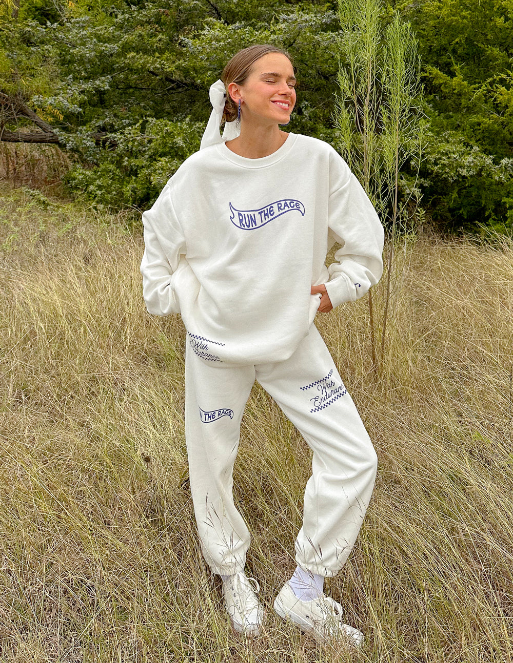 White unisex sweatpants with blue “Run the Race” logo and cuffed ankles