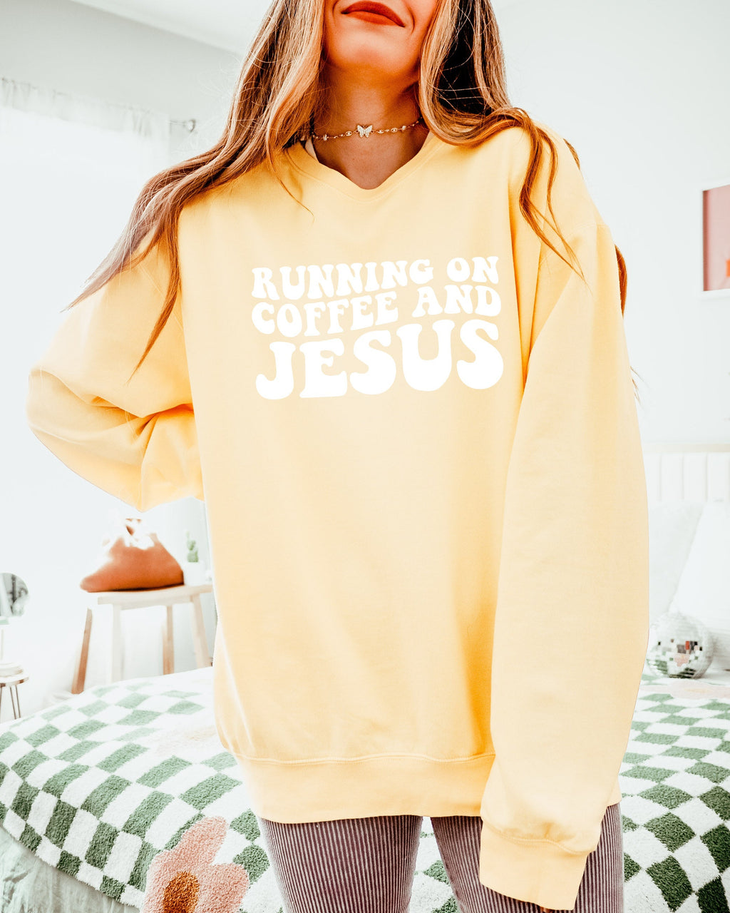 Light yellow sweatshirt with "RUNNING ON COFFEE AND JESUS" graphic on front.