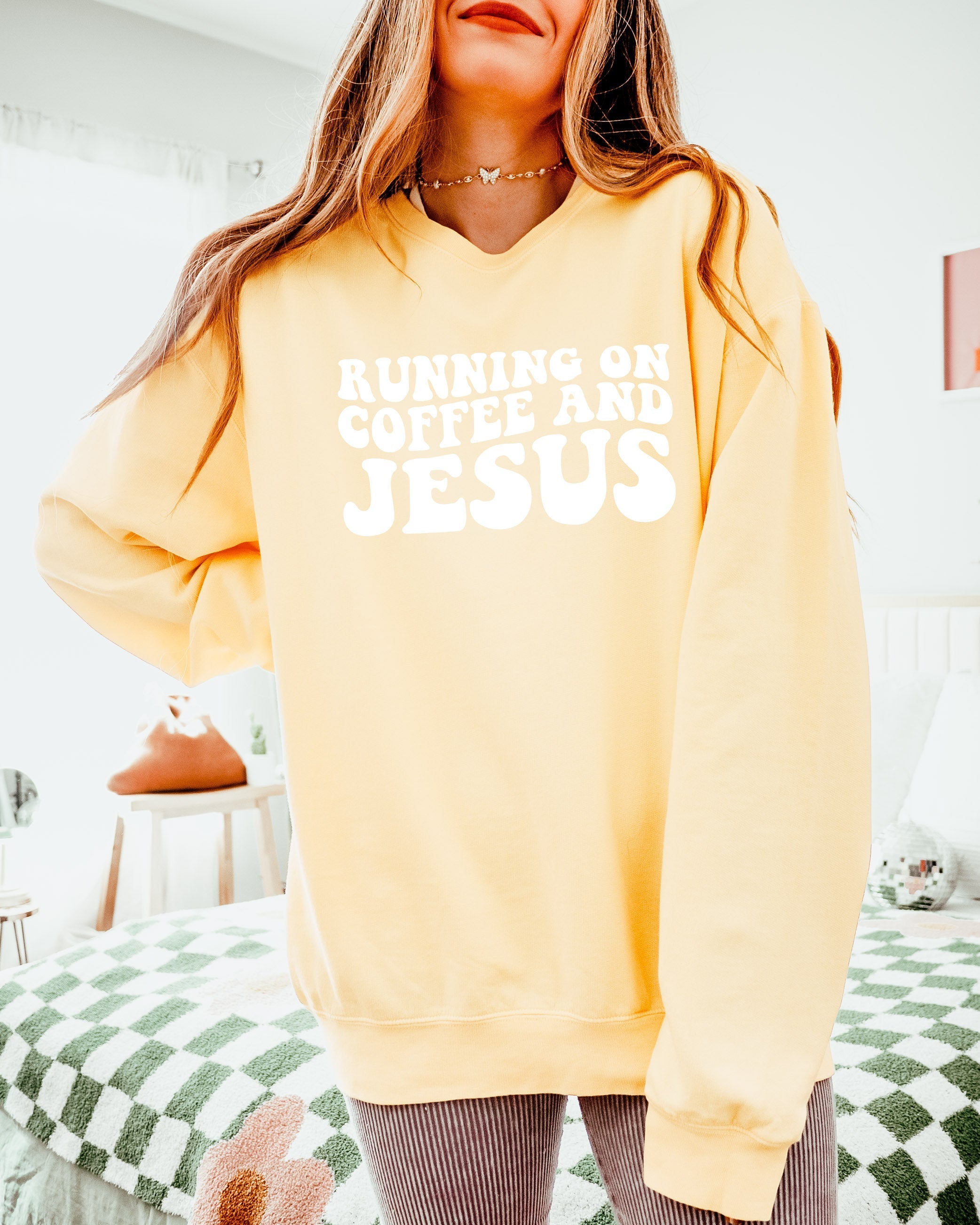 Light yellow sweatshirt with "RUNNING ON COFFEE AND JESUS" graphic on front.
