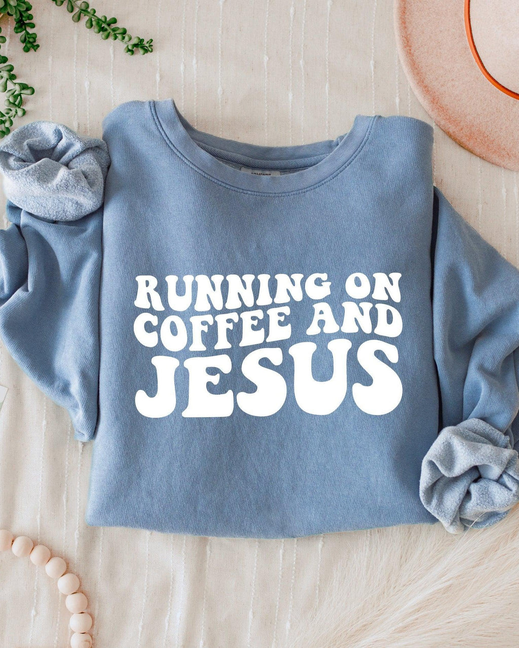 Blue-gray sweatshirt with bold "RUNNING ON COFFEE AND JESUS" text front.
