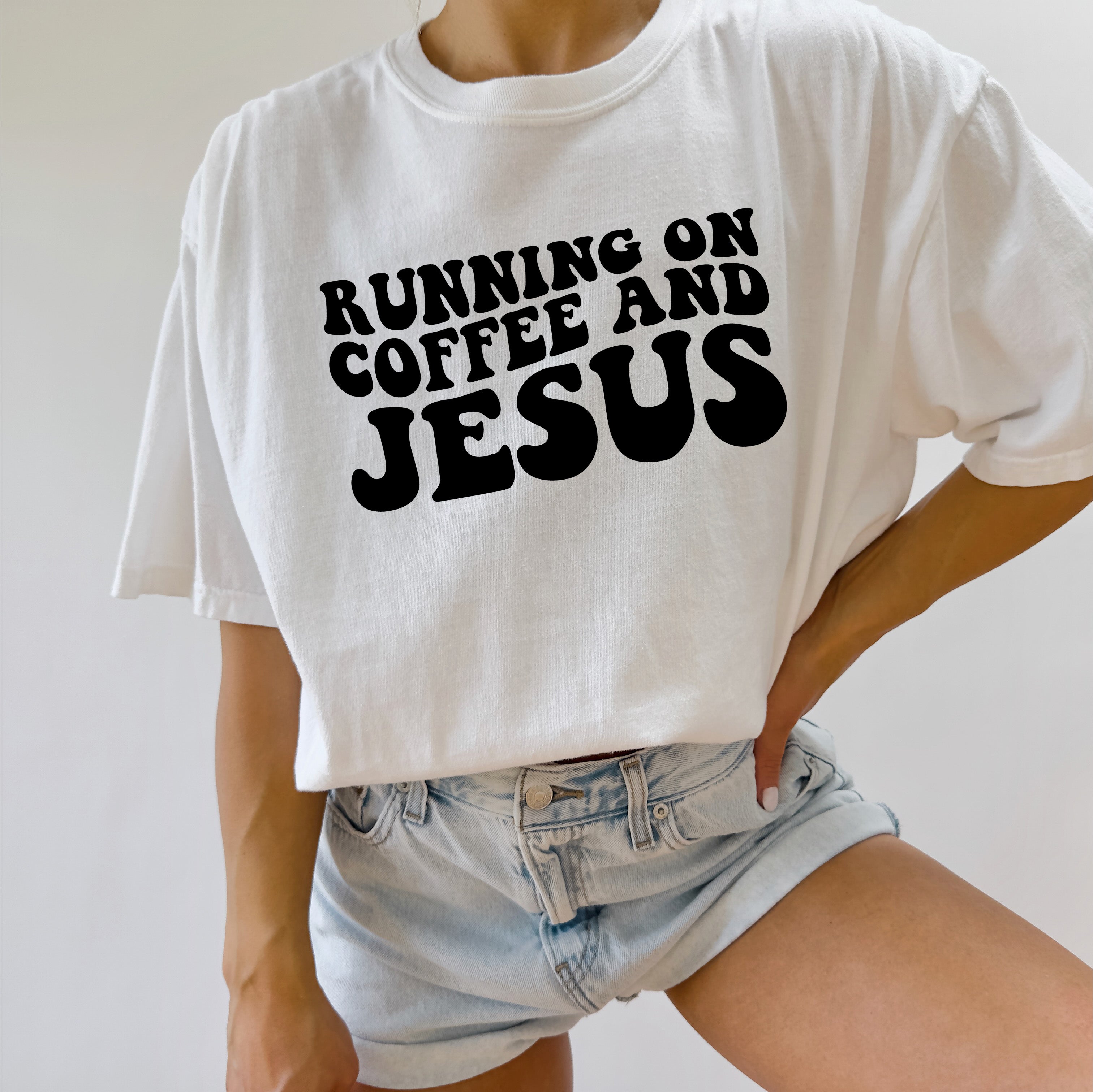 White graphic T-shirt with black RUNNING ON COFFEE AND JESUS lettering