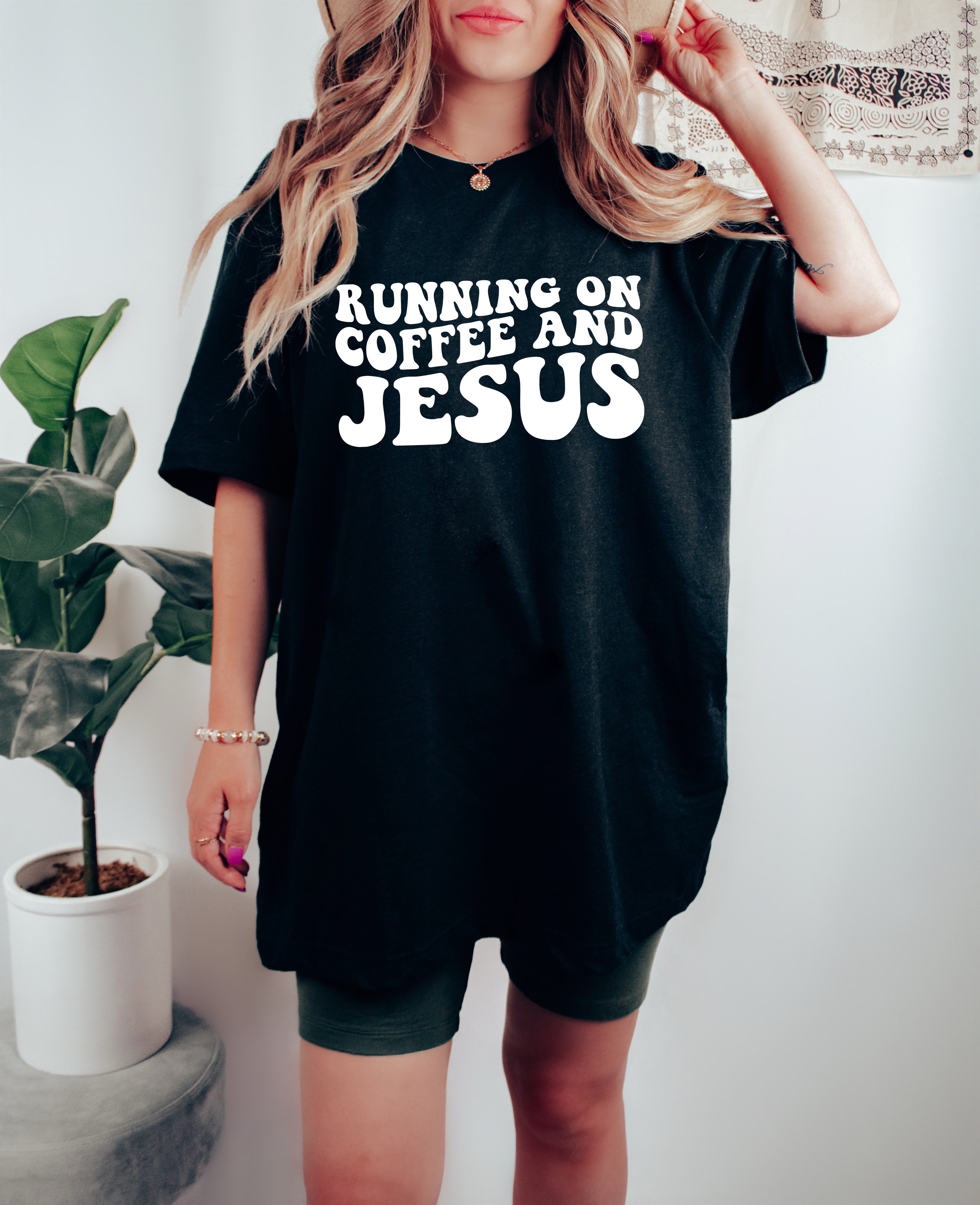 Black graphic T-shirt with white RUNNING ON COFFEE AND JESUS lettering