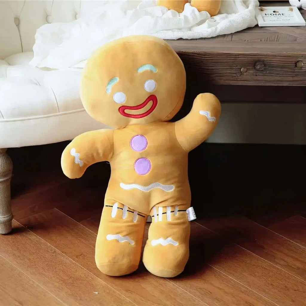 Standing gingerbread man plush toy with red smile, purple buttons, white icing and stitched feet.