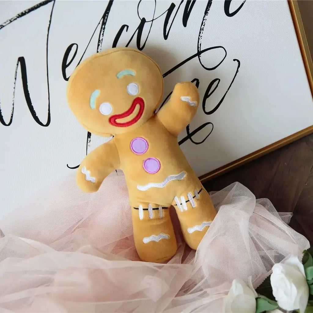 Gingerbread man plush in tulle skirt with red smile, purple buttons, and white icing lacing on feet.