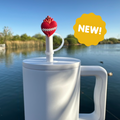 Red heart straw topper with crown and white loop handle, on a light-colored drink straw
