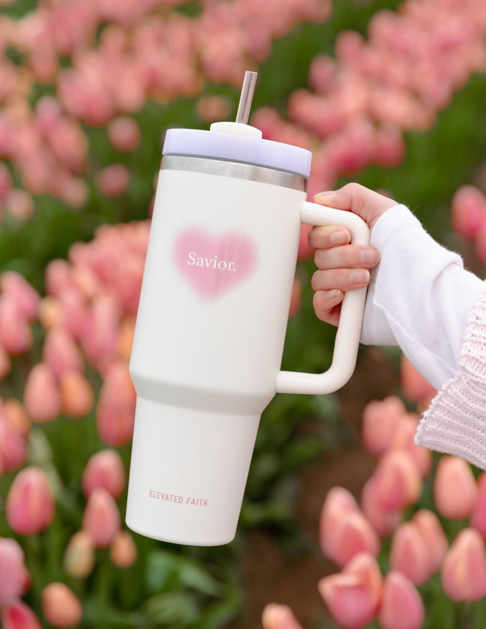 White 40 oz tumbler with pink heart logo, silver lid, and straw held by handle