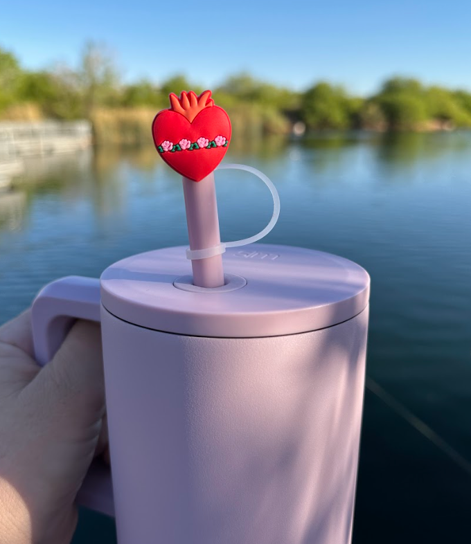 Red heart straw topper with crown detailing and small flower accents on a light straw