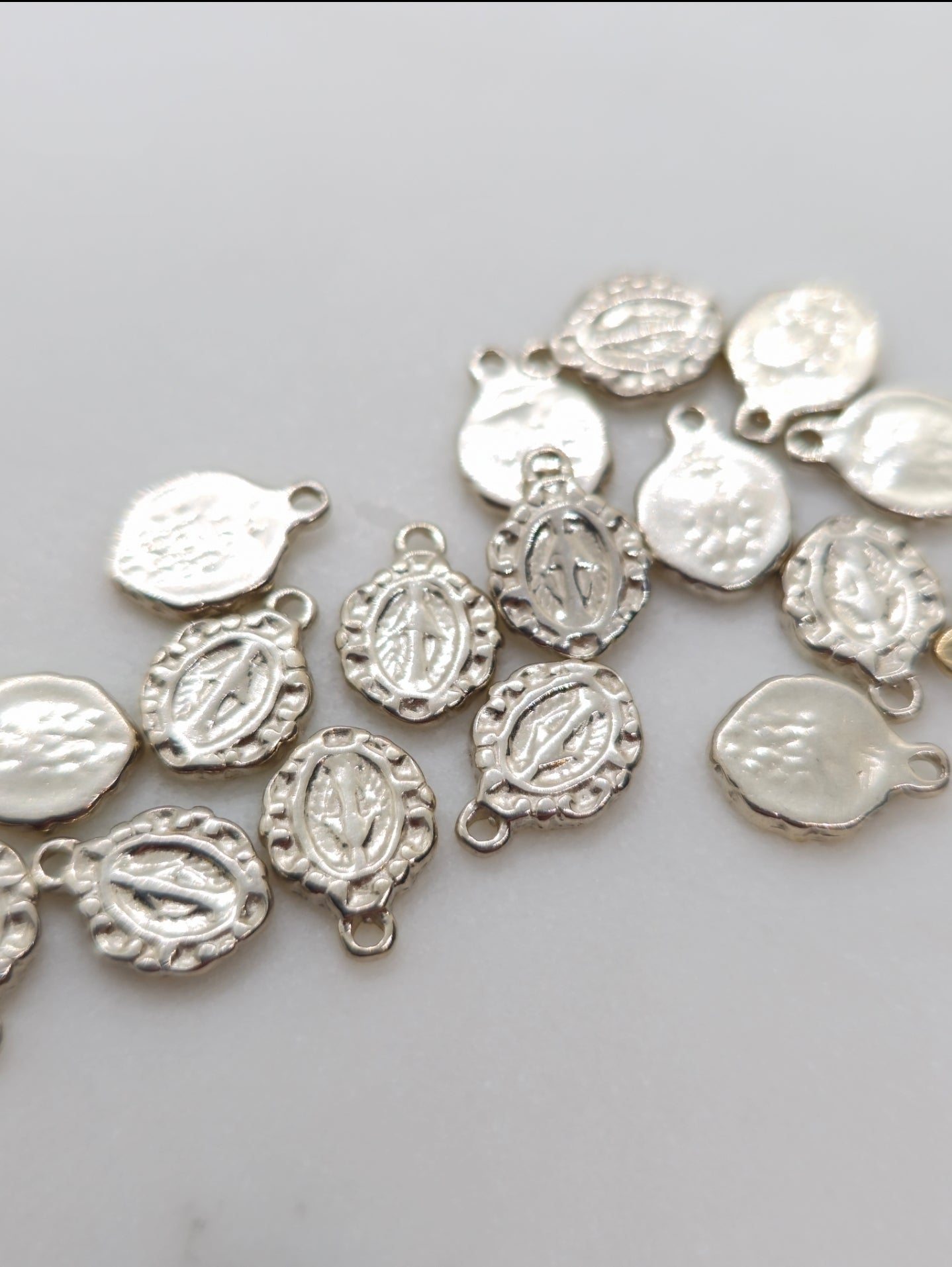 Sterling silver tiny oval medal charms with embossed figures, assorted