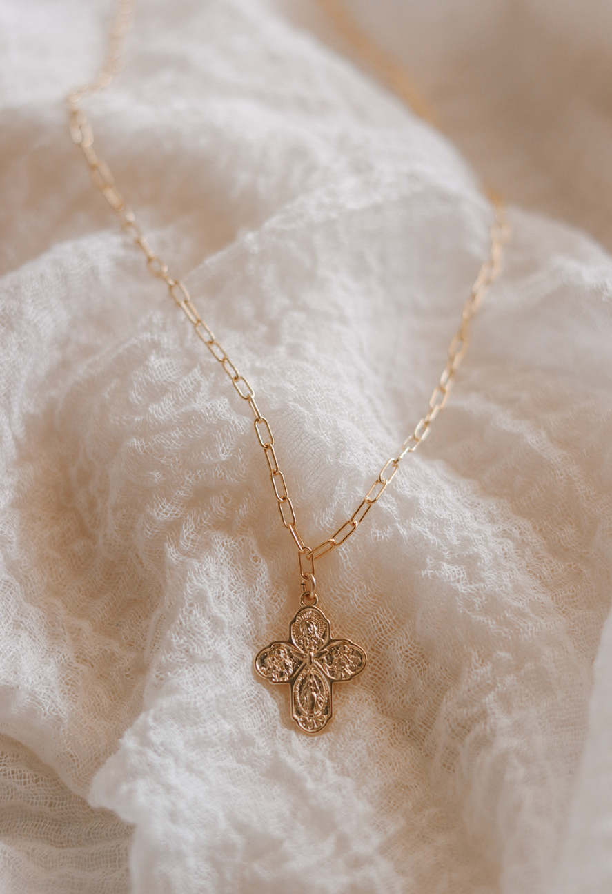 Gold cross pendant necklace with paperclip chain links, centered view