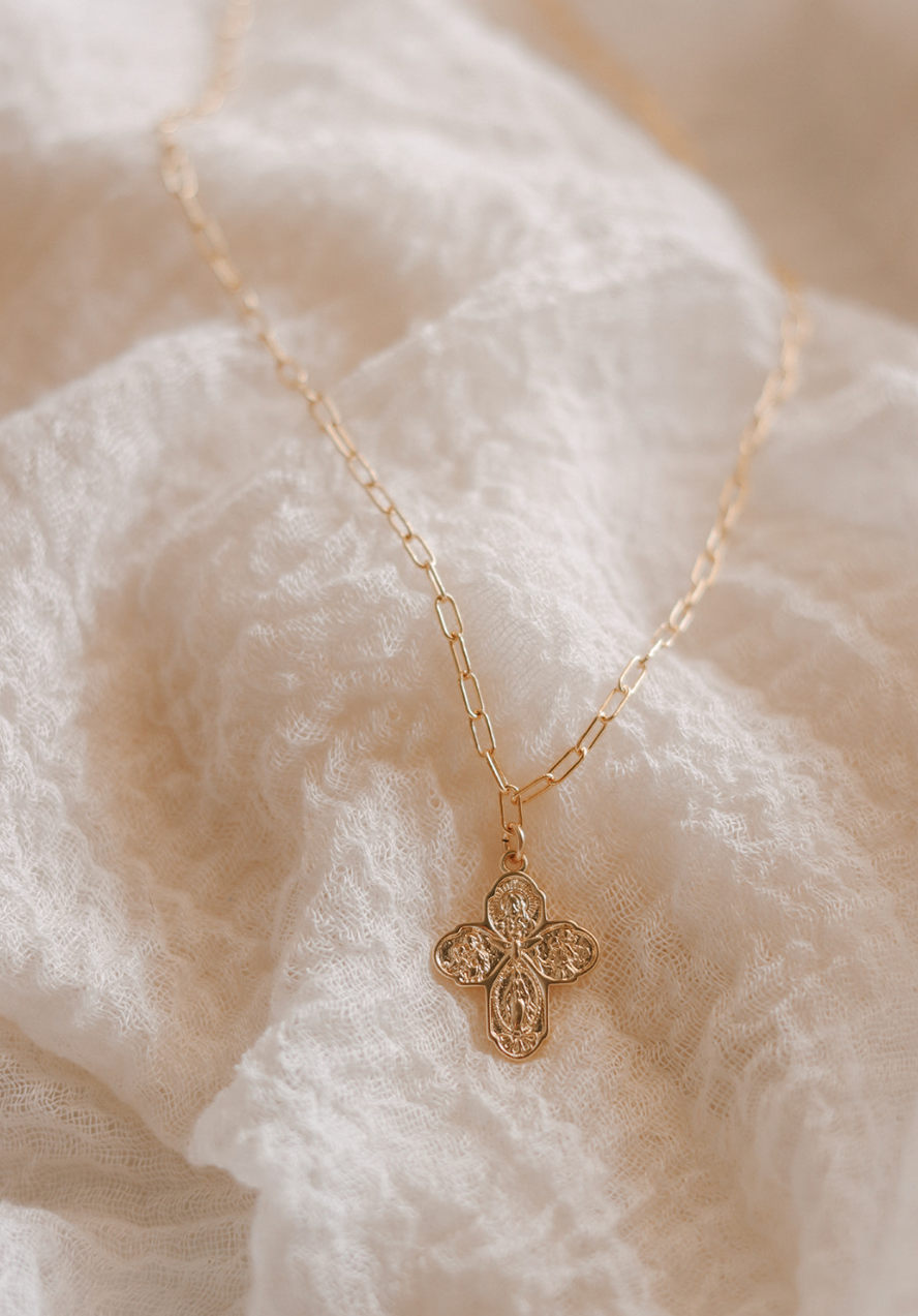 Gold cross pendant necklace with paperclip chain, centered view