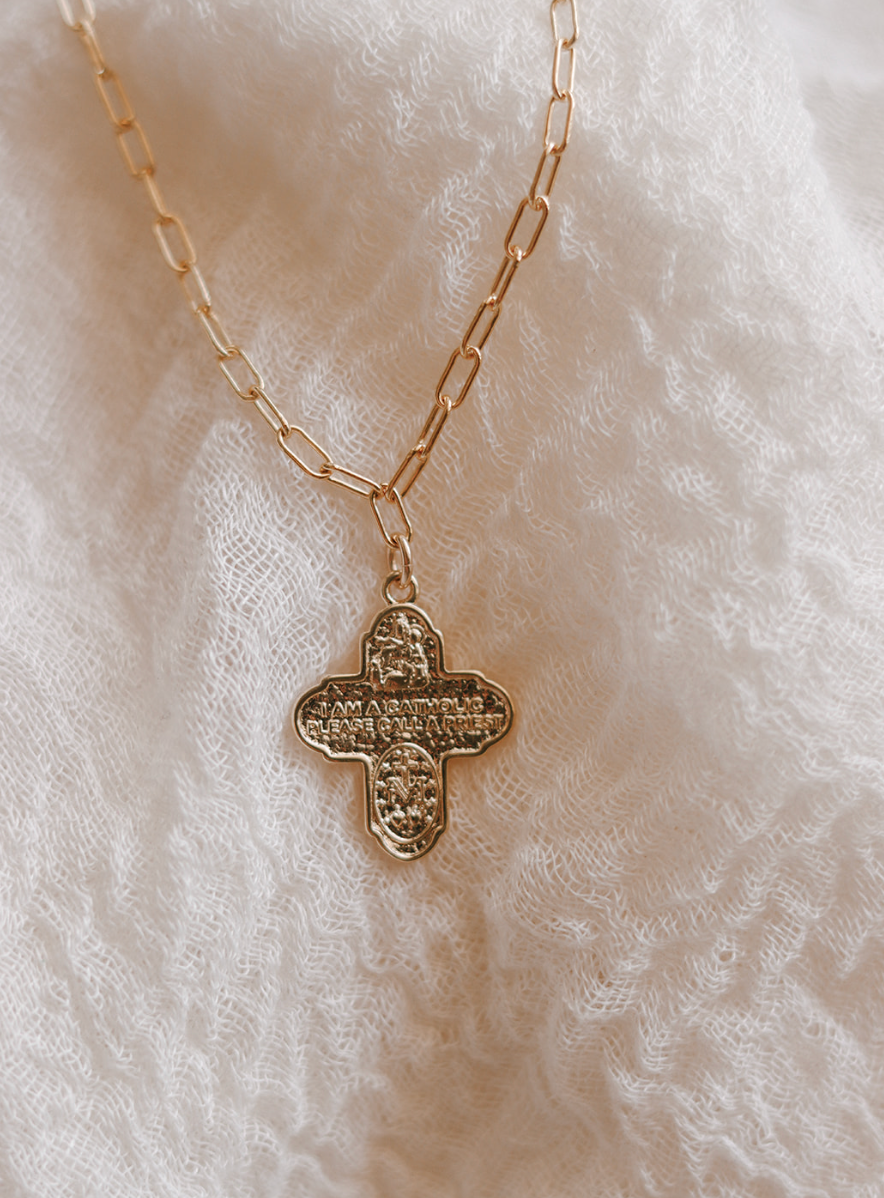 Gold paperclip chain necklace with four-leaf cross pendant and bail detail