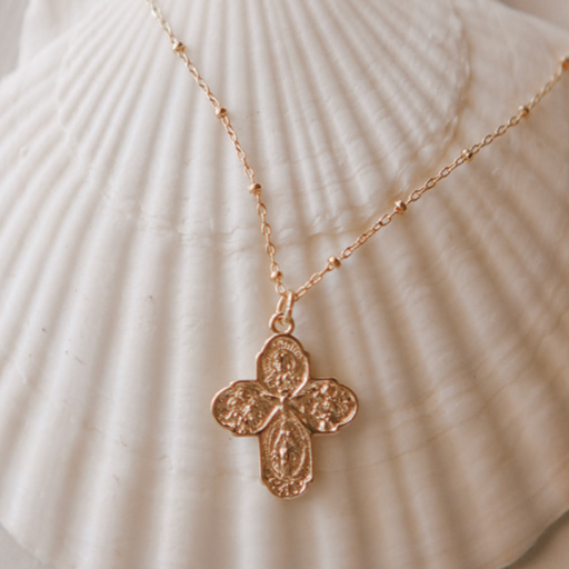 Gold-tone cross pendant necklace with delicate chain, full cross charm centered.