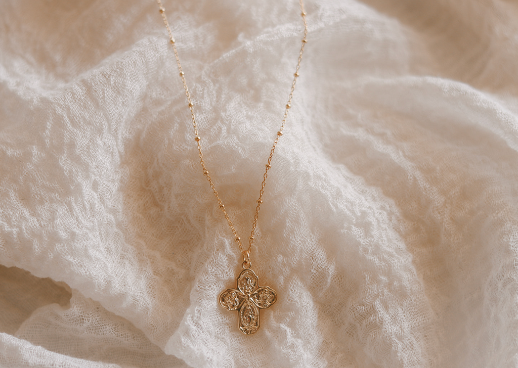 Gold cross necklace with detailed filigree pendant and thin chain
