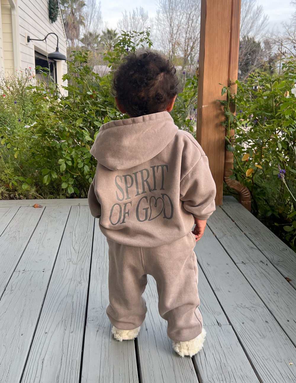 Kids taupe hoodie from behind with hood and “SPIRIT OF GOD” back graphic