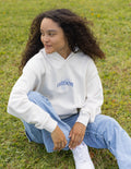 White unisex hoodie with blue "FREEDOM" logo on chest and relaxed fit