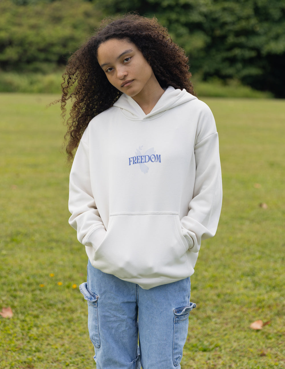 White unisex pullover hoodie with blue "FREEDOM" logo on chest and drawstring hood