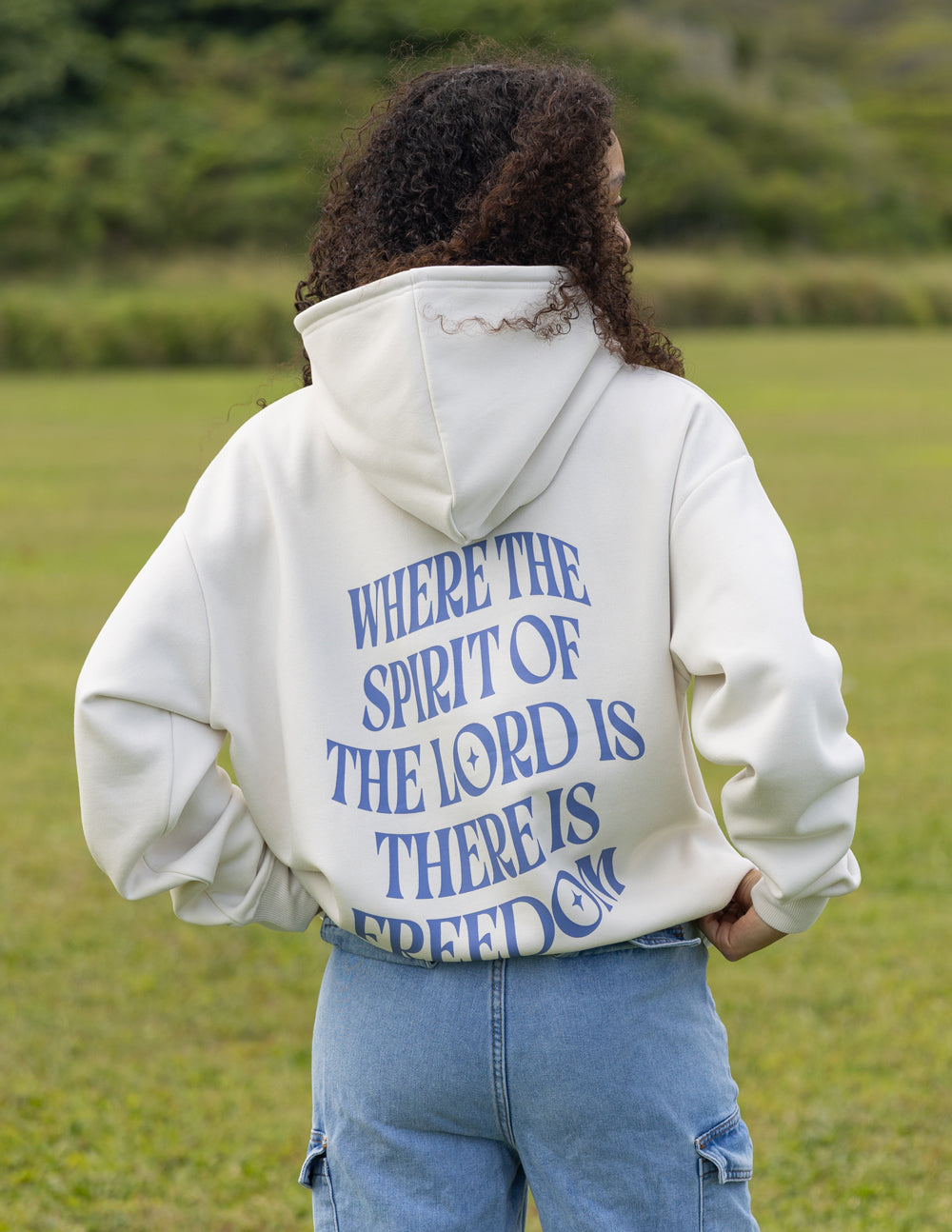 White unisex hoodie with blue back quote text, hood down and relaxed stance