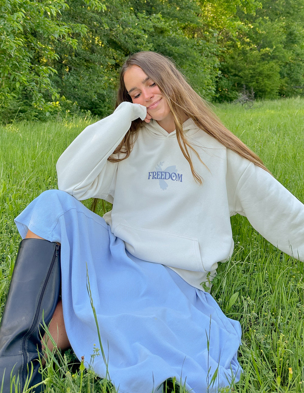 White unisex hoodie with blue 'Freedom' chest text, long sleeves and kangaroo pocket.