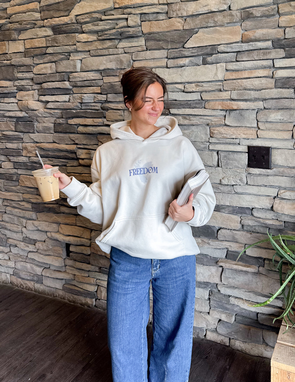 White unisex pullover hoodie with blue 'Freedom' chest logo and hood.